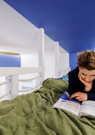 Teenage boy lying in high up entresol bed in his room. The boy is studying for school.
Shot with Canon R5
